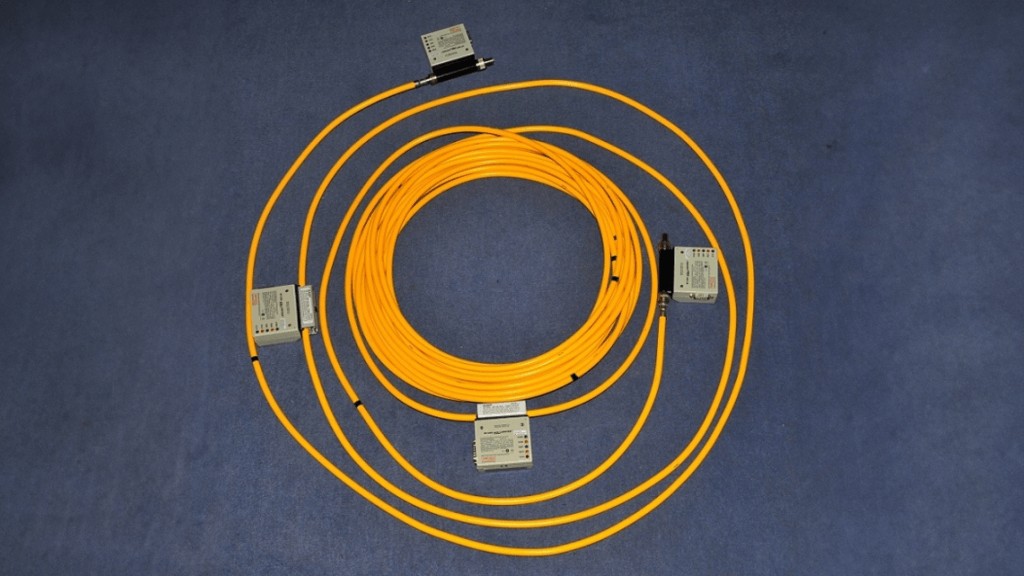 Cabo Thicknet (10BASE5) de grande diâmetro, utilizado em redes Ethernet antigas, mostrando os conectores e a estrutura robusta do cabo coaxial.